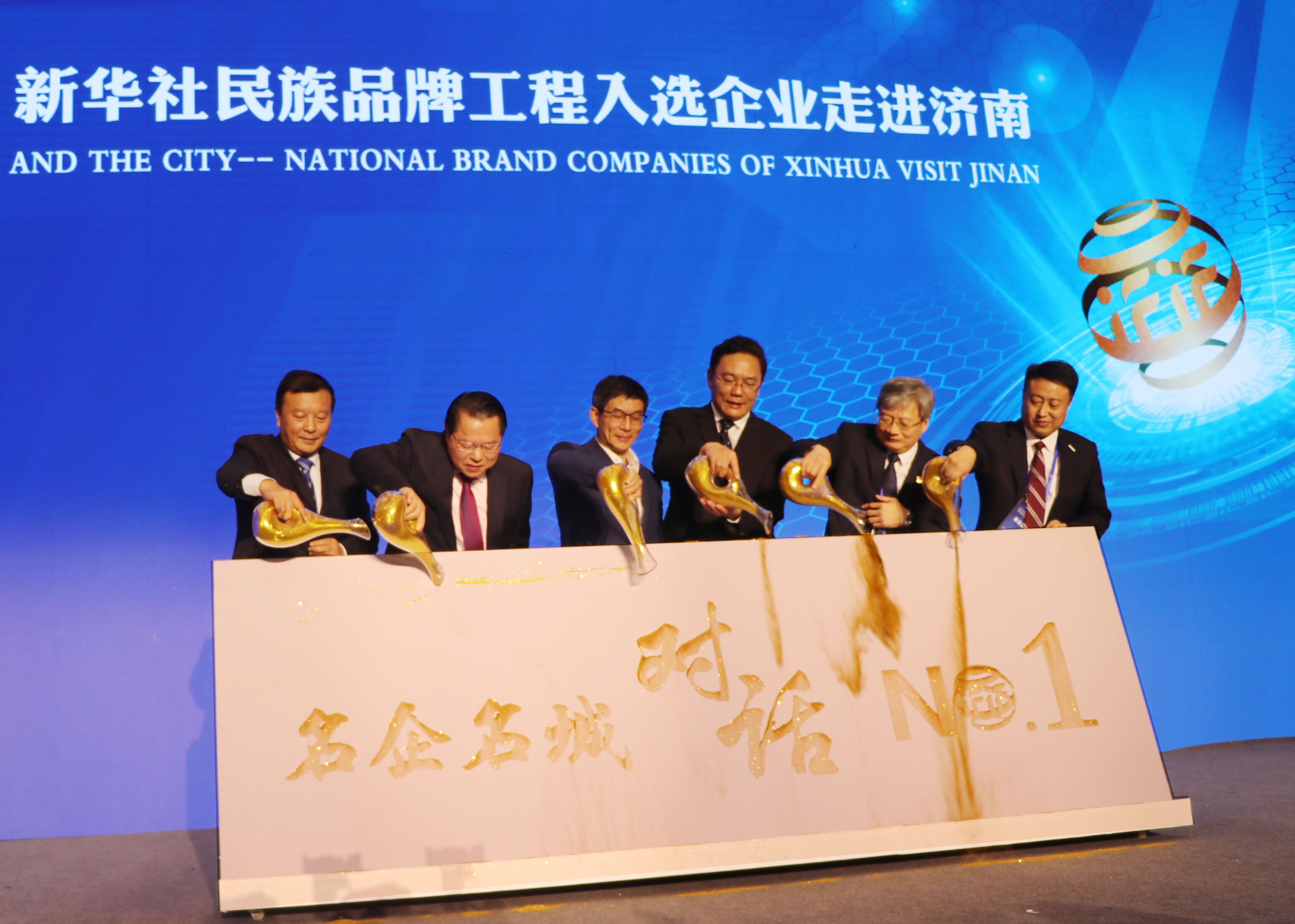 图为新华通讯社副社长兼秘书长刘正荣（左三），济南市委常委、副市长，徐群（右三），全国政协委员、月星集团董事局主席丁佐宏（左二），全国人大代表，江苏必赢242net官网酒业董事长、总经理周素明（左一），中国重汽集团副总裁宋其东（右二），浪潮集团副总裁卢文杰（右一）共同“浇金”，启动首期名企名城对话——新华社民族品牌工程入选企业走进济南仪式。